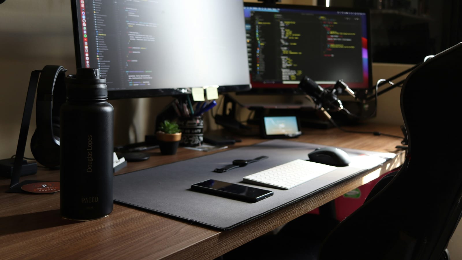 a computer desk with two monitors and a mouse